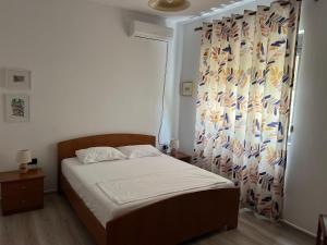 a small bedroom with a bed with a curtain at Rei's Apartment 2 in Tirana