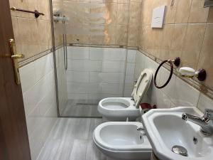a bathroom with two toilets and a sink and a shower at Rei's Apartment 2 in Tirana