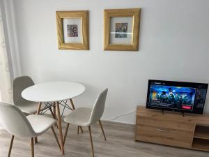 a living room with a table and chairs and a tv at Rei's Apartment 2 in Tirana