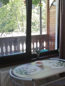a table with two plates on it in front of a window at Sofia Caffee Apart in Poiana Brasov