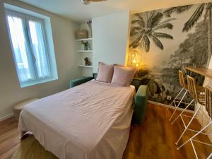 een slaapkamer met een bed met roze kussens erop bij Haut Chatelet in Orléans