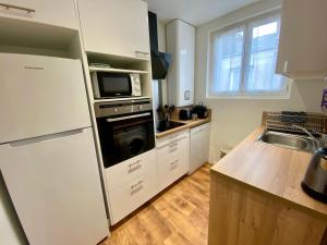 een keuken met een witte koelkast en een magnetron bij Haut Chatelet in Orléans