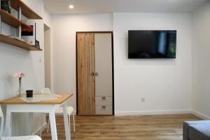 a room with a table and a door with a television at Lipowa Apartamenty B in Szczawno-Zdrój