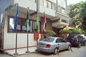 Ein Auto parkt vor einem Gebäude mit Flaggen. in der Unterkunft Salma Hotel in Kairo
