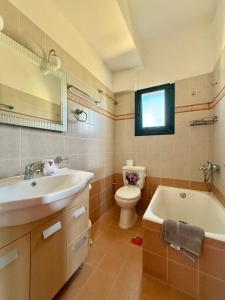 a bathroom with a sink and a tub and a toilet at The Twin Houses in Metamórfosis +31 photos