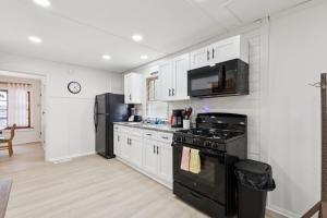  La cuisine est équipée d'une cuisinière noire et d'un réfrigérateur. dans l'établissement Dave's Last Resort-House on the Lake home, à Monticello