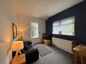 a living room with a couch and a tv at Garrick's Suite-Home away from Home- suitable for couples retreat, Contractors and NHS- free parking in Southport