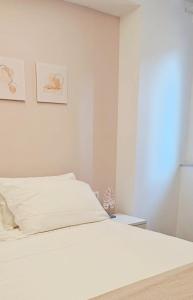 una camera da letto bianca con un letto e una finestra di NALI Apartment 1 a Civitanova Marche Altre 7 foto