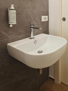 un lavandino bianco in un bagno accanto a un muro di NALI Apartment 1 a Civitanova Marche