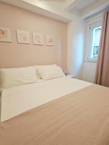una camera da letto con un letto bianco e una finestra di NALI Apartment 1 a Civitanova Marche