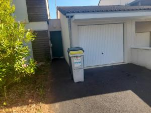 Un bote de basura estacionado frente a un garaje en POITIERS Séjour, en Poitiers