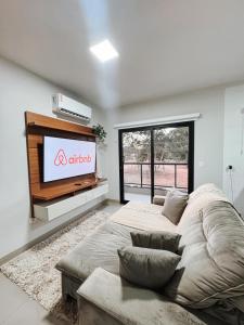 a living room with a large bed and a flat screen tv at APTO 100% Climatizado - Experiência Premium - Único na Cidade - Garagem Privativa p/ carros ñ atende caminhonetes. in Três Lagoas