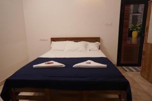 ein Schlafzimmer mit einem Bett mit zwei Handtüchern darauf in der Unterkunft The Beach Hive in Kappil