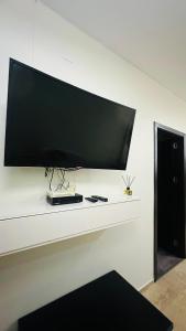 Un televisor de pantalla plana grande en una pared blanca en Batumi Center 3 Rooms City Side, en Batumi