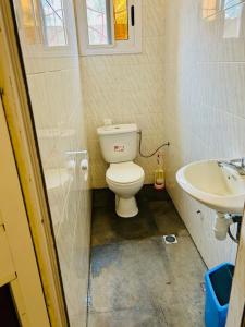 a small bathroom with a toilet and a sink at Résidence A2 in Komé