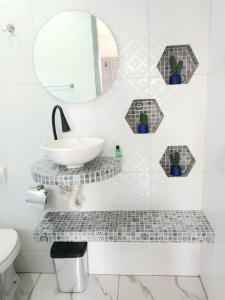 een badkamer met een wastafel en een spiegel bij Guará Apart 2 in Guaratuba +31 foto's