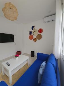 a blue couch in a living room with a table at Riad Casa Luafi in Tetouan