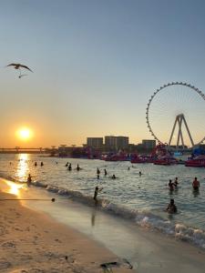 Alsahel Vacation 1 في دبي: مجموعة من الناس في الماء على الشاطئ