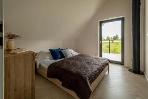 a bedroom with a bed and a large window at Cztery Pory Roku in Januszkowo +8 photos
