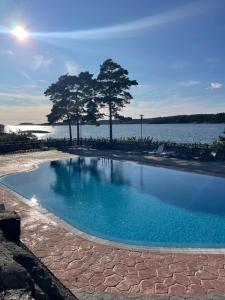 a swimming pool next to a body of water at Stuga i Hällestrand, Strömstad in Strömstad