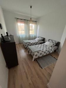 a living room with two beds and a table at Luxury 2 bedroom apartment and garden in Strzyżewo Witkowskie +9 photos