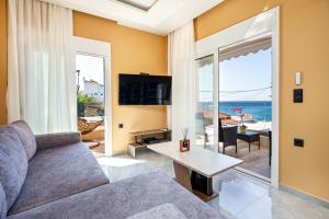 un salon avec un canapé et une vue sur l'océan dans l'établissement Aqua Velva Luxury Apartment, à Potos