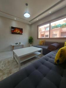 a living room with a couch and a table at Appartement centre ville in Oulad Akkou