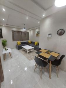 a living room with a table and a couch at Appartement centre ville in Oulad Akkou
