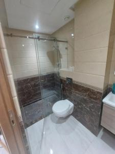 a bathroom with a toilet and a glass shower at Appartement centre ville in Oulad Akkou