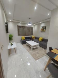 a living room with a couch and a table at Appartement centre ville in Oulad Akkou +2 photos