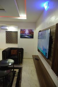 a living room with a flat screen tv on a wall at Tway Apartments in Ilorin