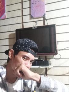 Un hombre con la mano en la cara delante de una computadora. en Cebu city, en Cebú