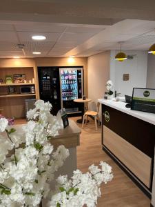 an office with white flowers and a counter at B&B HOTEL Viry-Châtillon 3 étoiles in Viry-Châtillon +28 photos