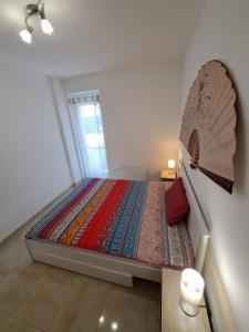 a small bedroom with a large bed with an umbrella at Mirtusz apartment in Balatonfenyves