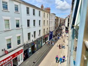 Un groupe de personnes marchant dans une rue avec des bâtiments dans l'établissement York City Centre 2-Bed Flat - Near Christmas Market, à York