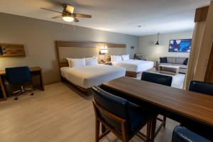 a hotel room with two beds and a table at Sonesta ES Suites Lafayette Airport in Lafayette