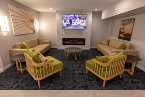 a living room with two couches and a tv at Sonesta ES Suites Lafayette Airport in Lafayette