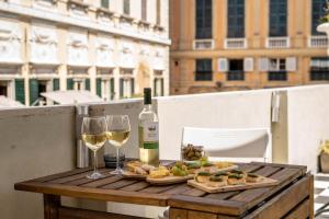 een tafel met een fles wijn en twee glazen bij La Genova storica dal monolocale in Genua +6 foto's