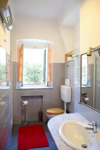een badkamer met een wastafel en een toilet en een raam bij La Genova storica dal monolocale in Genua