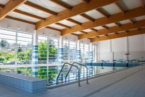 a swimming pool in a building with windows at Lipowa Apartamenty in Szczawno-Zdrój