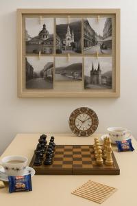 Un tablero de ajedrez y un reloj sobre una mesa en Anna Studio, en Brasov