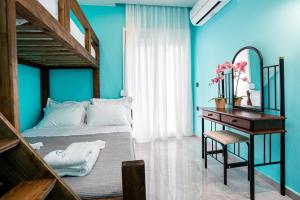 une chambre avec des murs bleus et un lit et un bureau dans l'établissement Aqua Velva Luxury Apartment, à Potos