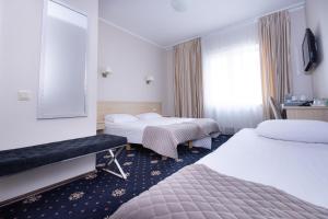 a hotel room with two beds and a window at Hotel SPA Arkadia in Apšuciems
