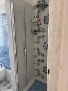 イスキアにあるDonna Flora Ischia appartamentoの浴室のガラス扉付きシャワー