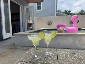 dois copos de margarita em um pátio com piscina em Sunkissed Sands em St. Augustine