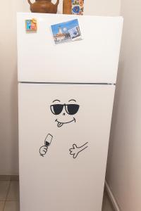 Un refrigerador blanco con una cara y gafas de sol. en Anna Studio, en Brasov