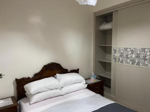 a bed with white sheets and pillows in a room at BLANCA BEACH- بلانكا بيتش سكن مشترك غرفة مزدوجة مكيفة لدى الساكن في I COLOCATION I Chambre double climatisée chez l'habitant dans une résidence pieds dans l'eau I FLAT SHARE I Air conditioned double room in a host's home within a waterfront residence in Sidi Rahal