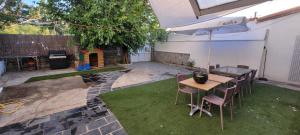 a patio with a table and chairs and an umbrella at Casa Riquelme 2 in Alpedrete