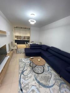 a living room with a blue couch and a table at Noema Apartment 5 Maji - A Cosy Stay in Tirana in Tirana