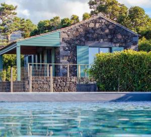 a house with a swimming pool in front of a house at Refúgio da Montanha in Lajido